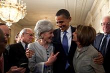 President Barack Obama embraces Secretary of Health and Human Services Kathleen Sebelius, left, and House Speaker Nancy Pelosi after signing the health insurance reform bill.Official White House Photo by Pete Souza